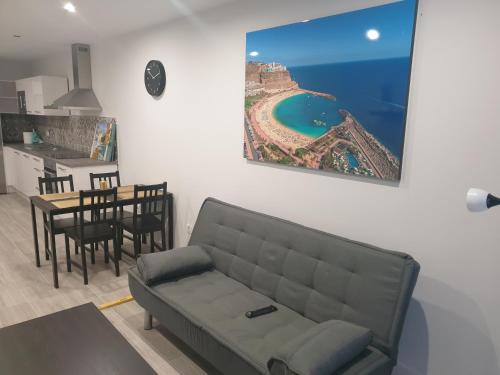 een woonkamer met een bank, een keuken en een tafel bij Guanarteme Vista Surf in Las Palmas de Gran Canaria