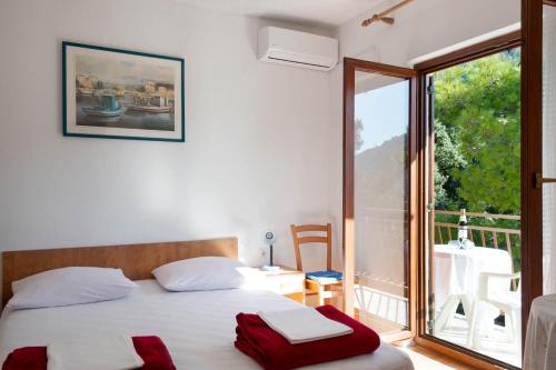 a bedroom with a bed and a large window at Niko Apartments in Drvenik