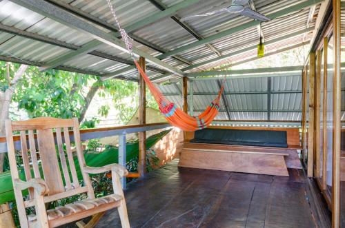 a hammock on a porch of a house at Tico Adventure Lodge in Sámara