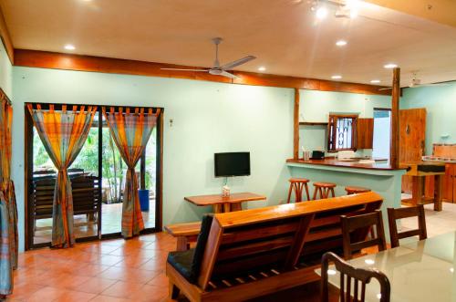 a living room with a bench and a table at Tico Adventure Lodge in Sámara