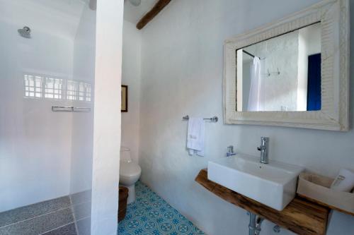 a white bathroom with a sink and a mirror at Casa La Bisbal in Cucunubá