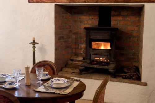 a dining room with a table and a fireplace at Casa La Bisbal in Cucunubá