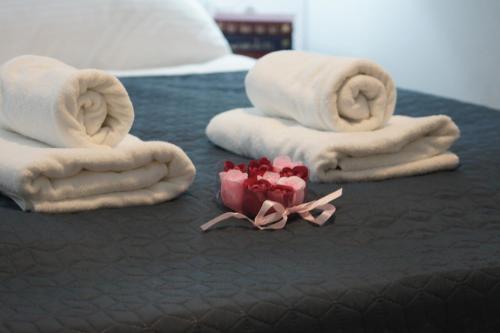 a bed with towels and a bouquet of roses at Apartament Elvira, Grunwaldzka 12C in Pobierowo