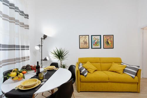 uma sala de estar com um sofá amarelo e uma mesa em Les Amis em Siracusa