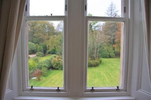 an open window with a view of a yard at Rudha-na-Craige in Inveraray