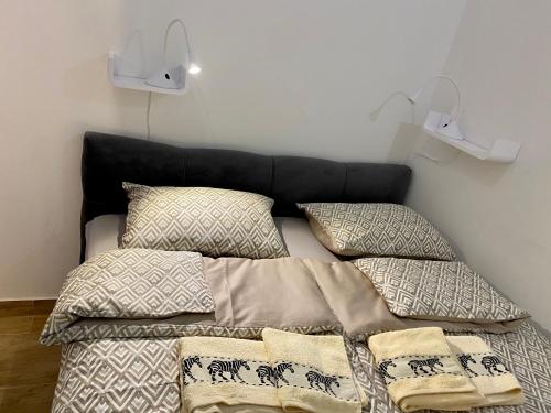 een bed met vier kussens erop bij Pearl Apartment Pula in Pula