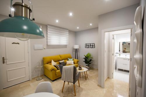 sala de estar con sofá amarillo y mesa en MAJESTUOSA ALHAMBRA Nuevo apartamento, en Granada