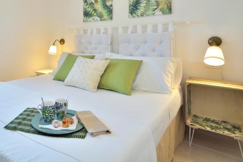 a white bed with a tray of food on it at VILLA FEDERICA CON PISCINA/WITH POOL in Santa Maria Del Focallo