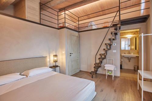 a bedroom with a large bed and a spiral staircase at EL TANO in Città della Pieve