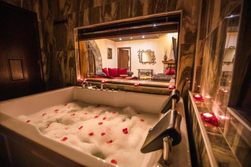 a bath tub filled with blood in front of a mirror at Vila Eden Boutique Hotel in Korçë