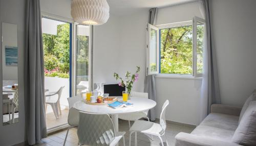 uma sala de estar com uma mesa branca e cadeiras em Aminess Port 9 Residence em Korčula