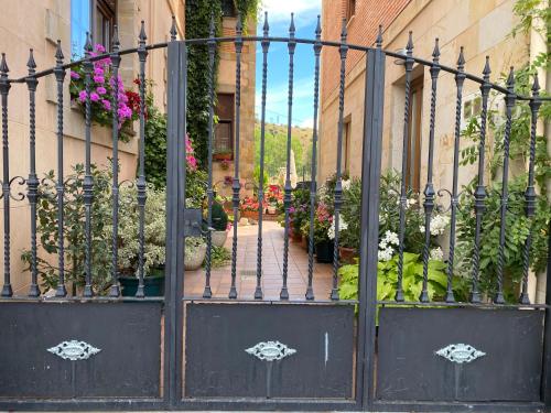 a black iron gate with flowers and plants at Hotel Rural Peñalabra in Cervera de Pisuerga