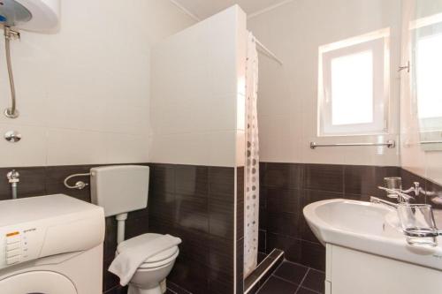 un baño con inodoro y lavabo en Apartments Forte Mare, en Herceg-Novi
