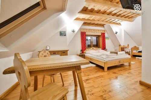 a living room with a table and a bed at Agroturystyka "Na Borowej" in Czarny Dunajec