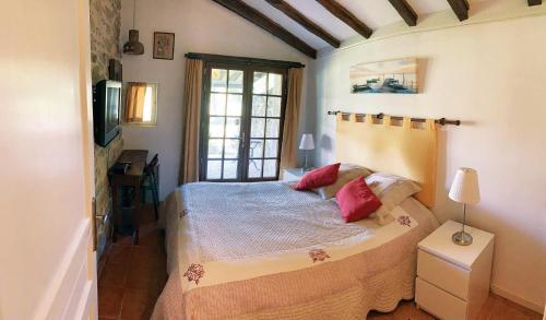La Bégude-de-MazencにあるGITE LA FREYDIEREのベッドルーム1室(赤い枕のベッド1台付)