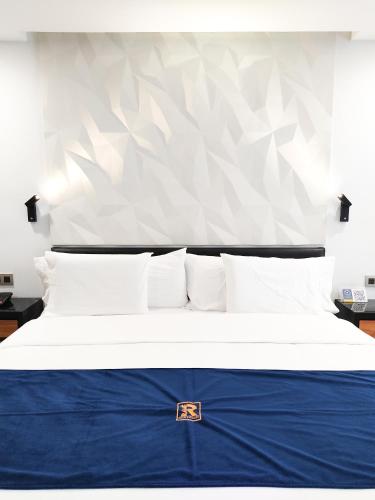 a bedroom with a bed with a blue blanket at Ramë Hotel Boutique in Guadalajara