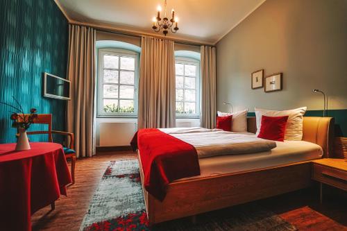 una camera da letto con un letto grande con una coperta rossa di Landgasthaus am Ufer a Traben-Trarbach