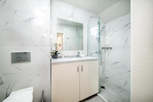 a white bathroom with a sink and a mirror at Boutique Guest House"Ruvan" in Burgas City
