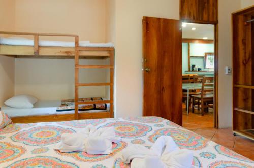 a bedroom with a bed with towels on it at Tico Adventure Lodge in Sámara