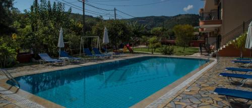 a large swimming pool with chairs and umbrellas at Nature & Blue in Parga