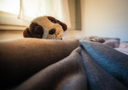 a stuffed animal laying on top of a bed at Dorfwirt Pfronten in Pfronten