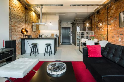 an industrial living room with a black couch and a red rug at LOFT apartment 200m to Old Town wi-fi/netflix in Olsztyn