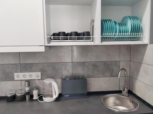 uma cozinha com um lavatório e um armário com pratos em Хостел с террасой в центре em Kharkov