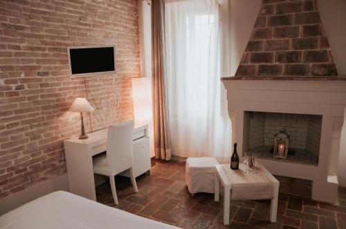 a living room with a fireplace and a bed at Relais Casetta 56 in Lugo