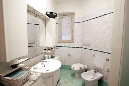 a white bathroom with two sinks and a toilet at L'eco delle sirene in Amalfi