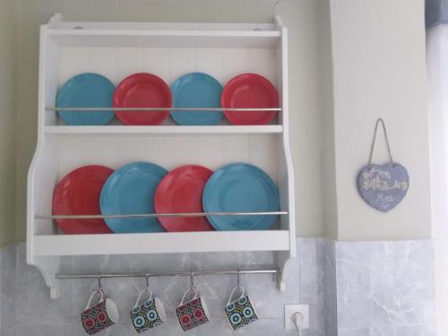 a shelf filled with red and blue plates at Pillbox Seafront Studios and Apartments in Kardamaina
