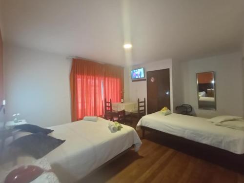a hotel room with two beds and a television at Isabela Hotel in La Paz