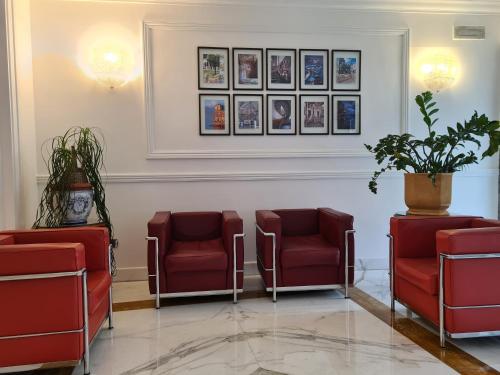 a waiting room with red chairs and pictures on the wall at Palazzo Turchini in Naples
