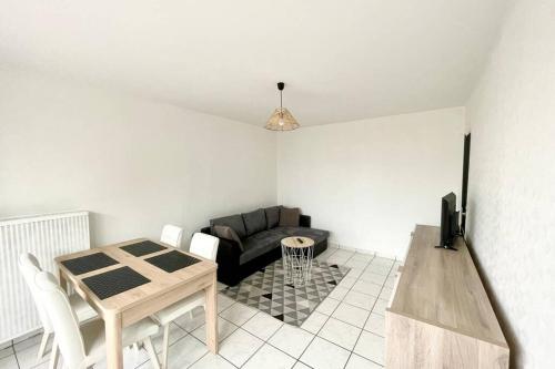 un salon avec une table et un canapé dans l'établissement L'Isernon - Spacieux T2 au bord de la rivière, à Annecy