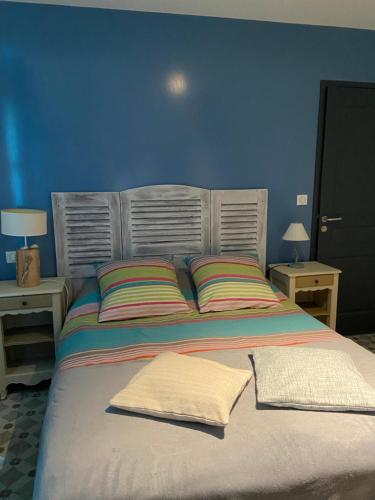a blue bedroom with a large bed with two pillows at Le Mahonia in Yport