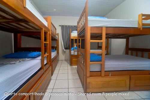 a dorm room with three bunk beds in it at Hostel Lençóis Park in Barreirinhas