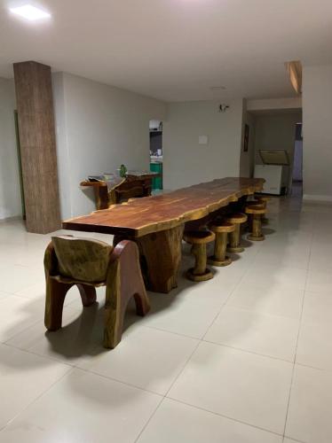 a long wooden table with a row of wooden benches at Casa de Praia Pitimbu in Pitimbu