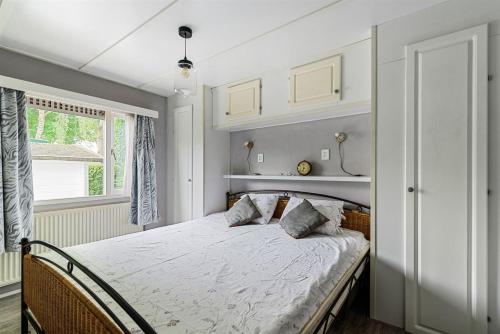 a bedroom with a bed and a window at Charmant chalet te Voorthuizen in Voorthuizen