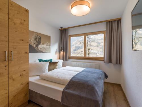 a bedroom with a bed and a window at Apart Huamatl in Ramsau im Zillertal