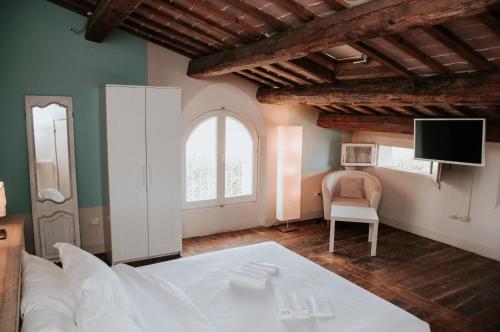 a bedroom with a white bed and white walls at Relais Casetta 56 in Lugo