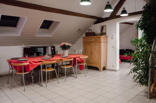 een keuken met een rode tafel en stoelen bij Hageland Vakantieverblijf in Holsbeek