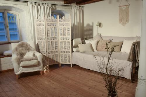 a living room with a bed and a chair at "Schwarzer Speicher" Stralsund in Stralsund