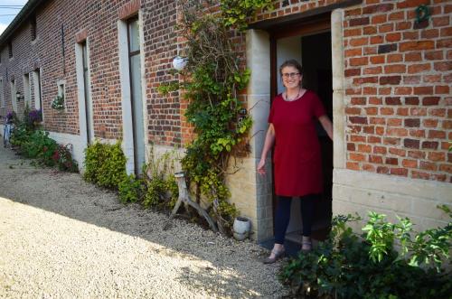 a woman standing in the doorway of a brick building at Hageland Vakantieverblijf in Holsbeek