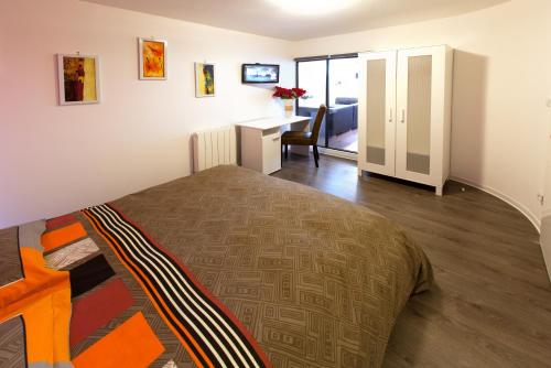 Un dormitorio con una cama y un escritorio en una habitación. en Le Corbeau - Grand Appartement Strasbourg Centre, Calme, en Estrasburgo