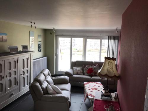 a living room with a couch and chairs and a table at Duplex Blankenberge in Blankenberge