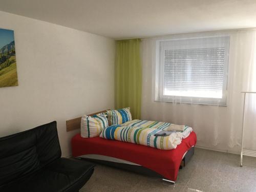 Una sala de estar con un sofá rojo y una ventana. en Fe wo Viktoria, en Lahr