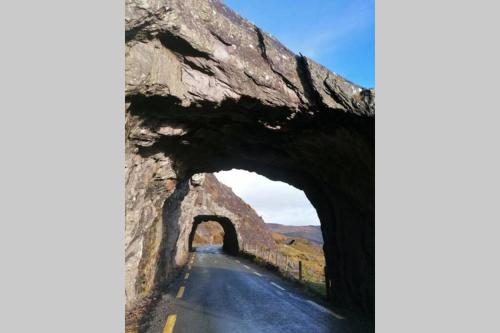an arch in a stone bridge over a road at Harbourside House Glengarriff in Glengarriff