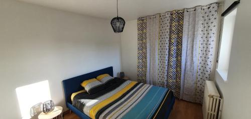 - une chambre avec un lit et une fenêtre avec des rideaux dans l'établissement Les toits de Dieppe - appartement en plein cœur du centre ville, à Dieppe