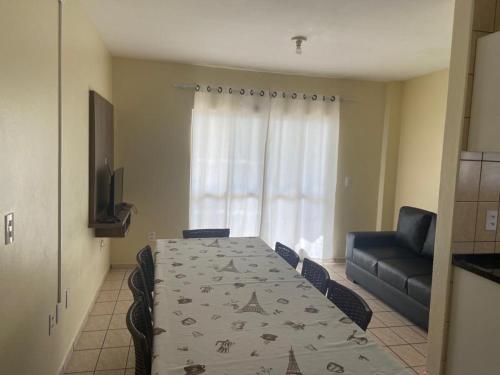 a dining room with a table and a couch at Apto Frente Mar in Itapema