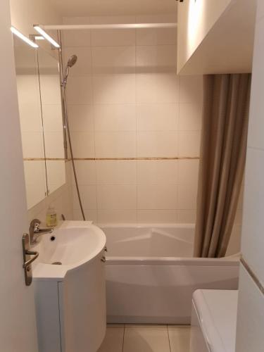 une salle de bain avec un lavabo et une baignoire dans l'établissement L'Escale à Deauville, à Deauville