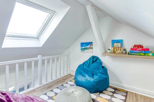 a room with a blue bag on the floor in a attic at Escale pro & détente à 3 min de la gare - Parking - WIFI - PS4 in Corbeil-Essonnes